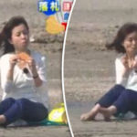 Girl Sitting On A Beach Eating Does Not Expect This To Happen